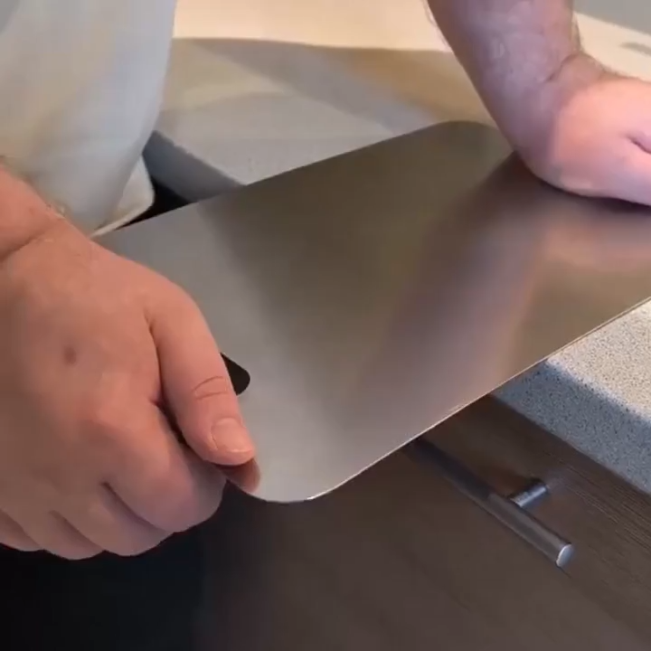 Hands holding the thin, double-sided titanium board